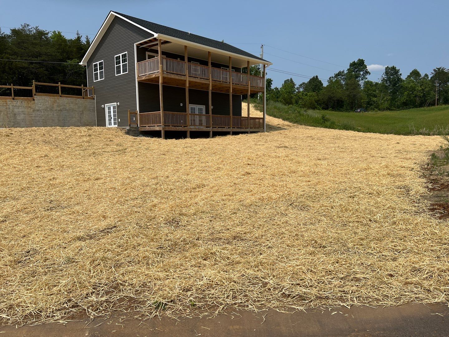 Two-story gray siding home with double deck