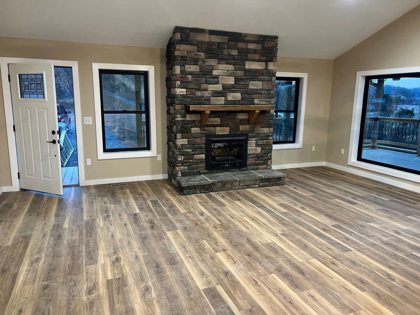 Living room with stone fireplace and hardwood floors