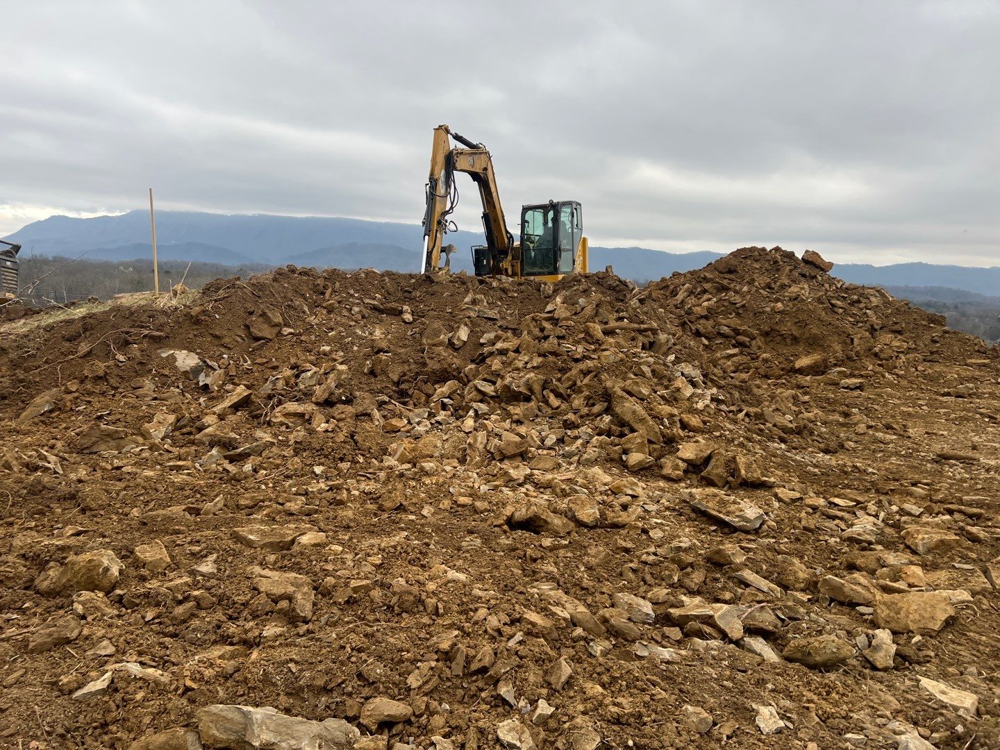 CAT excavator on rocky mountain site