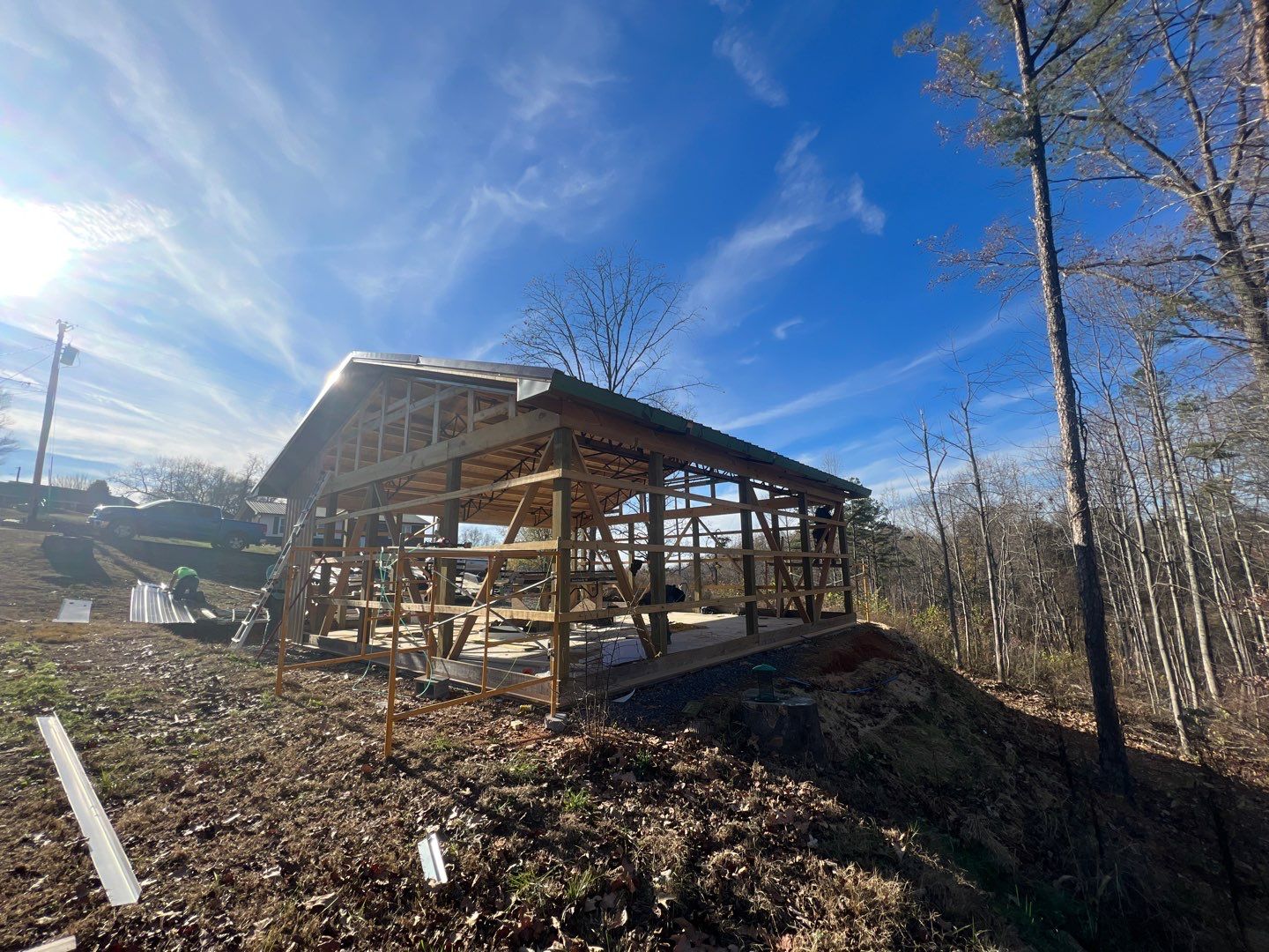 Post frame building with scaffolding and roofing